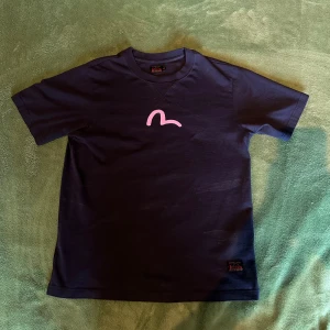 Evisu T-shirt - Marinblå T-shirt från Evisu, köpt på NK Göteborg för 1299kr, storlek M. Skick 9/10, använd endast någon gång. 