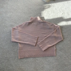 Gammel rosa stickad polotröja - Säljer en helt ny (oanvänd) stickad polotröja med långa ärmar och ribbade detaljer vid krage, ärmslut och nederkant. Jätte fin stickad tröja i bra skick.