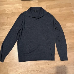 Mörkgrå tröja från Massimo Dutti - Säljer en stilren mörkgrå tröja från Massimo Dutti. Tröjan har en klassisk krage och långa ärmar, perfekt för en elegant look. Materialet känns mjukt och bekvämt, vilket gör den idealisk för både vardag och mer formella tillfällen. Skicket är 10/10 och finns inga defekter. 