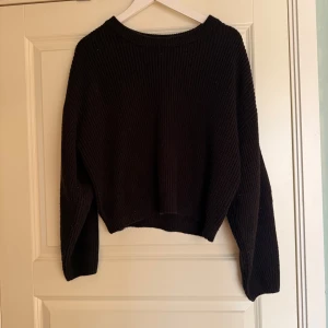 Svart stickad tröja - Säljer en svart stickad tröja med långärmad design. Perfekt för kyligare dagar med sin mysiga och varma känsla. Enkel och stilren, passar till många olika outfits.