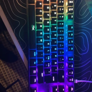 HyperX mekaniskt tangentbord med RGB-belysning - Säljer ett HyperX mekaniskt tangentbord med RGB-belysning. Tangentbordet har en kompakt design utan numerisk del och röda brytare för snabb respons. Perfekt för gaming och skrivande med stilfulla ljuseffekter.