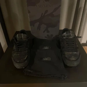 Valentino rockrunners  - Snygga svarta sneakers från Valentino med ett diskret camouflage-mönster. Skorna kommer i originalförpackning. Perfekta för en stilren look.