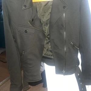 Svart jacka med dragkedja och knappar - Snygg svart jacka med asymmetrisk dragkedja och knappar.