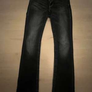 Mörkblå jeans från True Religion - Snygga mörkblå jeans från True Religion med rosa detaljer. Säljer eftersom att de inte kommer till mycket användning. Inte mycket använda och bra skick. Storleken 28 vilket passar mig som är 175 mycket bra.