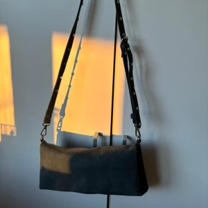 Mörkgrå axelväska med nitar - Justerbart band med silver nitar, går att göra ännu kortare om man vill göra egna hål! Mockaimitaton 🖤⚡️