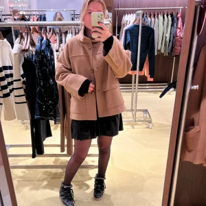 Beige kappa från Gant - Slutsåld i alla storlekar. Nypris 3300kr. Säljer en stilren beige kappa från Gant. Jackan har en hög krage och stora fickor framtill. Perfekt för att hålla sig varm och snygg. Passar bra till både casual och mer uppklädda tillfällen.