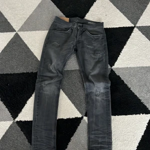 Svarta jeans från DonDup  - Snygga svarta jeans från DonDup med slitna detaljer. De har en modern passform och är perfekta för en trendig look. Jeansen har klassisk femficksdesign