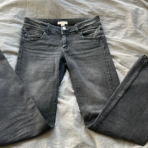 Jättefina grå bootcut jeans från Gina Tricot - Snygga grå jeans från Gina Tricot i storlek 164. De har en klassisk femficksdesign med två knappar och dragkedja framtill. Perfekta för en stilren look. Jeansen är lågmidjade 