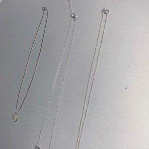 Tre silverhalsband med olika berlocker - Säljer tre stilrena silverhalsband med olika berlocker. Ett halsband har en blomformad berlock, det andra har en oändlighetssymbol och det tredje har en berlock med ett dekorativt mönster. Perfekta jag kommer sälja den alla tre för 600kr annars om jag kommer sälja en kostar 190kr