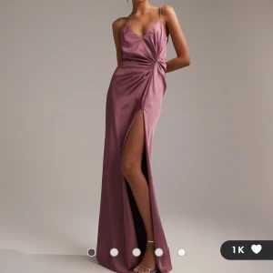 Ljuslila långklänning från ASOS Edition - Säljer denna superfina lila/rosa klänningen från ASOS Edition i satin med smala axelband. Klänningen har en slits framtill och en v-ringad design. Perfekt för speciella tillfällen såsom balen eller bara till sommaren. Säljer då jag hittade en annan klänning och missade att lämna tillbaka denna i tid. Nypris 1279kr. Pris kan diskuteras!❣️❣️