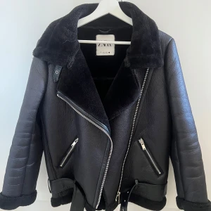 Svart skinnjacka  - En snygg och stilren svart skinnjacka med bälte och fluffig insida som värmer bra. Jackan är använd några gånger, men i övrigt i väldigt bra skick. Skriv gärna för mer bilder, mått och funderingar🩷