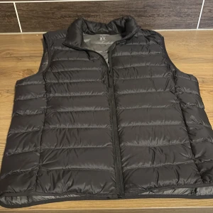 Svart dunväst  - Säljer en stilren svart dunväst från Uniqlo. Västen är lätt och har en dragkedja framtill. Väldigt skön dässutom och i väldigt bra skick. Pris kan diskuteras!