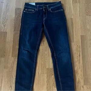 Mörkblå jeans från Dondup - Snygga mörkblå jeans från Dondup och har storleken 28. Jeansen har en skinny passform. De är i väldigt fint skick och är köpta för några veckor sedan. Nypris ligger på runt 3000 och mitt pris är 699. Kan även gå ner en del i pris vid snabb affär! Hör av er vid frågor eller funderingar! 