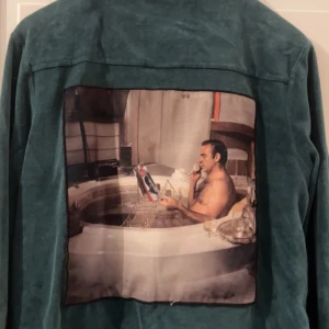 Limitato overshirt zip grön - Snygg grön mockajacka med ett unikt tryck på ryggen. Jackan har en dragkedja framtill och långa ärmar. Perfekt för dig som vill sticka ut med en cool och annorlunda stil. 