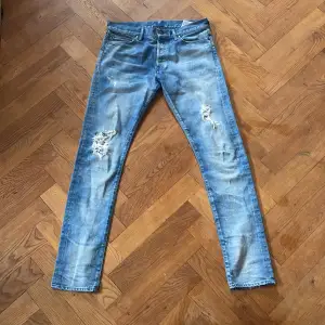 Feta jeans med slitningar och lite färgstänk som design, slim fit. Skick 10/10. Vid minsta lilla fråga är det bara att höra av sig