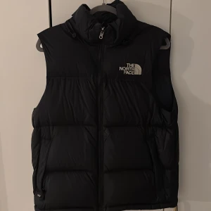 North face nuptse väst - Säljer en bästa helt ny North face väst i storlek S, nypriset ligger runt 3000kr. Vid frågor/funderingar kontakta säljaren!