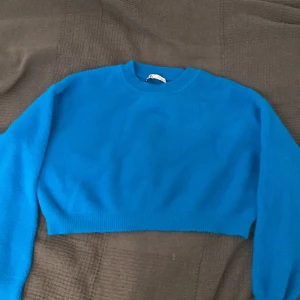En blå stickad tröja - Blå stickad tröja i gott skick. Den är öiten i storleken 