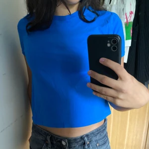 T-shirt  - Blå t-shirt, lite mindre passform. Nästan som en magtröja. Säljer då stilen inte passar mig. Ganska tunt men bekvämt material. 