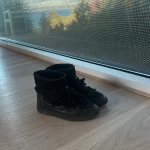 Svarta sneakers från Inuikii - Säljer ett par svarta vinterskor från Inuikii. De är i skinn och har en cool, hög design med snörning. Perfekta för höst och vinter med sin robusta stil. Skorna är i bra skick och redo för nya äventyr!