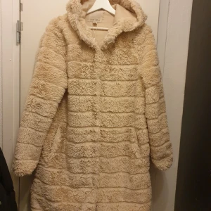 Beige teddyjacka från Amisu - Säljer en supermysig beige teddykappa från Amisu i storlek L. Den är perfekt för kalla dagar med sin fluffiga och varma design. Jackan har långa ärmar och en stor huva som gör den extra gosig. Perfekt för höst och vinter!🤎