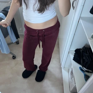 Vinröda mjukisbyxor - Säljer ett par supermysiga vinröda mjukisbyxor. De är högmidjade med en bekväm passform och har snörning i midjan för justerbarhet. Perfekta för en chill dag hemma eller en avslappnad promenad. Materialet är mjukt och skönt, vilket gör dem till ett måste i garderoben!