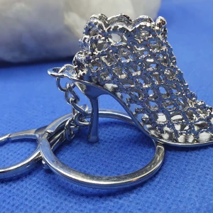 Nyckelring - Högklackad sko - Nyckelring i form av en högklackad sko, passar även som väsksmycke. Storlek på själva skon är ca 5 × 4 cm, längd på hela nyckelringen är ca 12 cm.