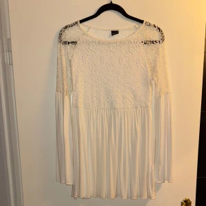 Vit spetsblus från Gina Tricot - Säljer en superfin vit spetsblus från Gina Tricot. Den har långa ärmar och ett vackert spetsmönster över axlarna och bröstet. Perfekt för både vardag och fest! Blusen är i storlek S och har en lös passform som ger en skön och luftig känsla.