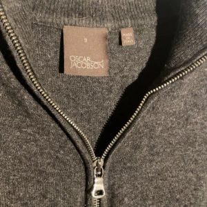 Oscar jacobson half zip - Säljer en mycket fin Oscar Jacobsson half zip tröja i ull och Kashmir. Använd varsamt därav väldigt fint skick. Tröjan är i mörkgrå o passar perfekt nu till hösten när det blir lite mörkare. Nypris ligger runt 1600kr och tröjan är i storlek s. 