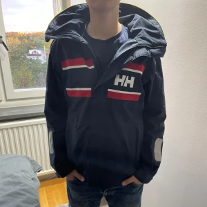 Helly Hansen regnjacka  - En blå Helly Hansen regnjacka i storlek S! Den är vind och regntät och är en perfekt höstjacka. Den är i superfint skcick och har inga defekter. Nypriset är 1500kr