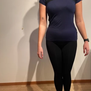 NY: Marinblå t-shirt med svarta paljetter, Esprit. Med lappar - Material: 100% viskos och 100% polyuretan  Tvättråd: 30°  Nypris: 199 kr
