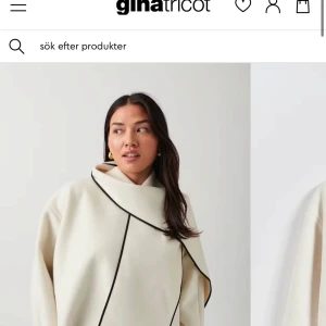 Beige kappa från Gina Tricot - Snygg och stilren vit kappa från Gina Tricot med svarta detaljer. Perfekt för höst och vår, med en elegant design som passar både till vardags och fest. Kappan har en unik krage och är långärmad. Köpt för 699 kr och säljer för 400 kr