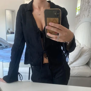 svart blus med knytning  - svart blus i linne från zara, den har knytning fram till och i armarna! storlek xs och är i fint skick 
