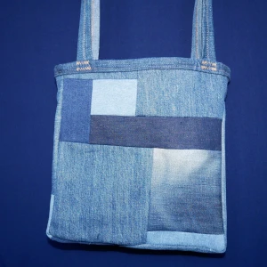 Handsydd axelväska "Äppelpaj"  - Blandade material, främst denim 100% återbruk Storlek: ca 26x24cm Band: ca 72cm Dragkedja: Nej Effekt: man kan bära äpplen i den