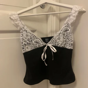 Svart linne med spets - Säljer detta helt nya linnet från shein som har spets och lite volang på banden, lite intimissimi inspirerad 🤩 den är helt ny, bara provad. Säljer då det ej är min stil! Nypris är 89 kr, bra kvalité 💞