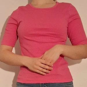 Rosa ribbad tröja - Rosa ribbad tröja med kortare ärmar från Kappahl.  (Sista bilden visar tröjans material)