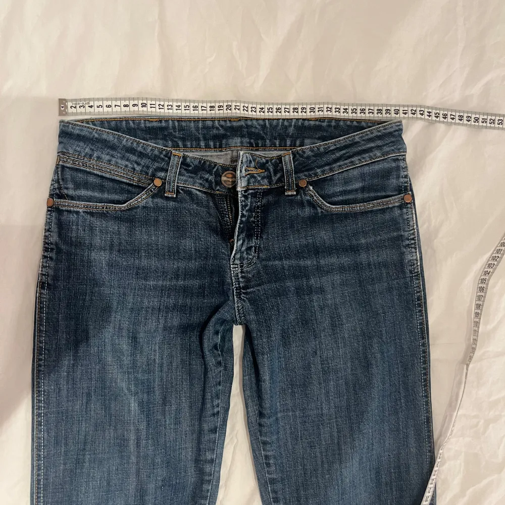 Säljer ett par snygga blå jeans med bootcut. De har en klassisk femficksdesign och är lågmidjade. Midjemåttet ligger på 40 cm rakt över och inre benlängden är ca 71-74cm. Perfekta för både vardag och fest! 🕺. Jeans & Byxor.