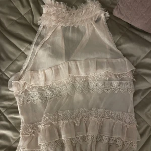 Rosa/beige topp - Rosa/beige topp med spetsdetaljer. Genomskinlig och i gott skick med resår längst ned och fin krage. 