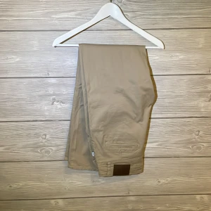 Beige chinos - Säljer ett par snygga beige chinos av märket Vailent som är perfekta för både vardag och lite mer uppklädda tillfällen. De har en klassisk stil och är gjorda i ett bekvämt material. Passar perfekt till höst och vår!