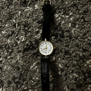 Classy guld svart klocka - Fin guld och svart klocka. Klockan saknar batteri men funkar även bara som assecoar🙏 Stainless steel och äkta läder!