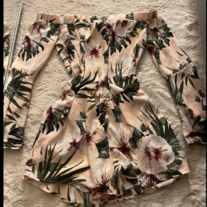 flower print short jumpsuit  - den är jätte pösig/ luftig och hade passat perfekt utomlands de har insydda shorts och två fickor den är off shoulder och är i bra skick  storlek 36 EU
