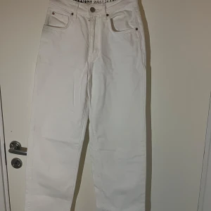 Vita jeansbyxor - Säljer ett par vita jeansbyxor i straight fit. De är högmidjade och har en klassisk design med fem fickor och knappgylf. Perfekta för en stilren look året runt!
