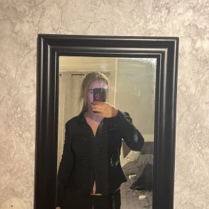 Svart fest topp - Det är en fin figursydd topp, den är svart och har scrunch i både ärmar och vid knäppning, den passar bra till fest men även till jobb, då den både går och klä upp och klä ned 