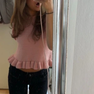 Rosa stickad topp med volang - Säljer en superfin rosa stickad topp med volangdetaljer. Den är lite croppad och perfekt för sommardagar. Toppen har en söt stil som passar både till vardags och fest. Perfekt att matcha med jeans eller kjol!