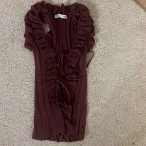 Vinröd blus med volangdetaljer - Säljer en superfin vinröd omlottklänning från Zara💕. Den har snygga volangdetaljer längs kanterna och är gjord i ett ribbat material som ger en skön passform. Perfekt för höst och vinter, och funkar lika bra till fest som till vardags.💕