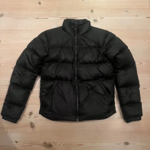 North face jacka  - Säljer min snygga och sköna North face jacka med svart logga. Den är i fint skick förutom den lilla lagningen på ena bilden. Har ni frågor är de bara att skicka!