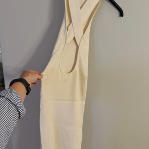 LXA stickad vit klänning öppen rygg - Så fin klänning. Öppen rygg, slit längs benet. Använd en gång, som ny i skicket. Benvit / äggvit 