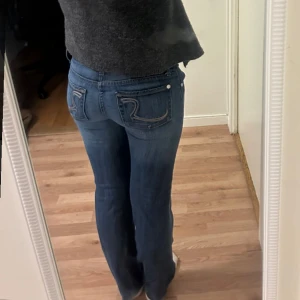 Mörk blå jeans med mönster där bak  - Säljer mina jeans då dom inte kommer till användning (använda max 2 ggr.)  Dom är lågmidjade och bootcut, skriv vid frågor 💕