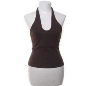 Brun halterneck topp - Snygg brun halterneck topp som är perfekt för sommaren. Den har en tight passform och är ärmlös, vilket gör den superbekväm och luftig. Perfekt för en dag på stranden eller en somrig festkväll! Vintage H&M. 