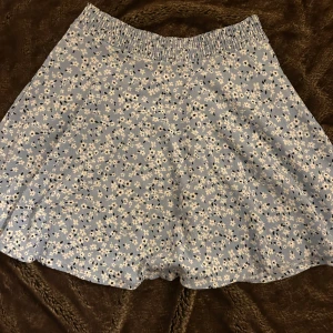 Blommig blå kjol - En blommig blå fin fladdrig kjol ifrån Lager 157. Nästintill oanvänd, så väldigt bra skick. Säljer då den är för stor för mig.