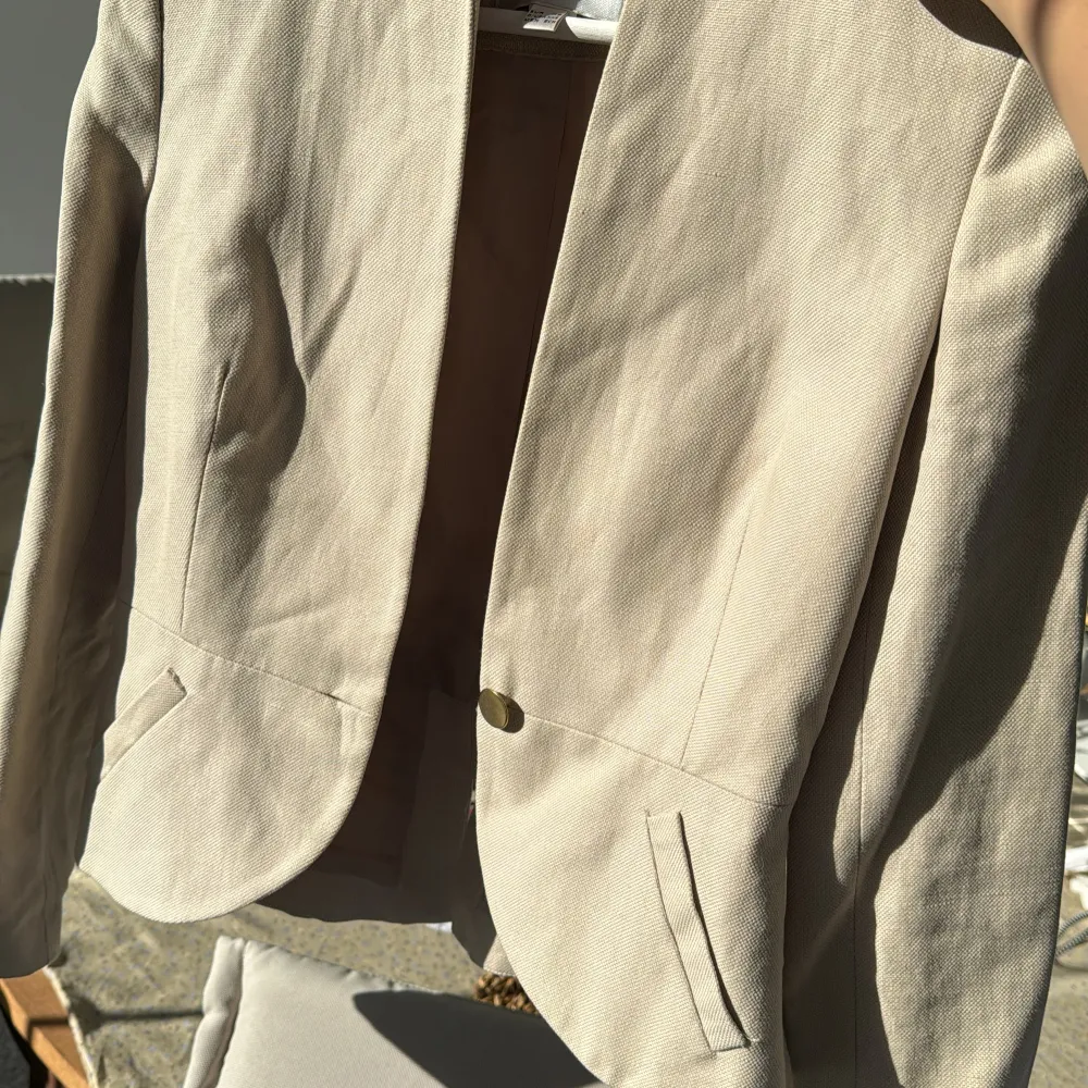 Säljer en snygg beige kavaj från MNG (Mango) i storlek XS. Den har en elegant design med en knapp framtill och långa ärmar. Perfekt för både vardag och festliga tillfällen. Kavajen är i bra skick och har en stilren look som passar till det mesta.. Jackor.